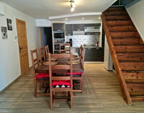 a dining room with a wooden table and a kitchen at Maison au cœur du Revermont in Ménétru-le-Vignoble