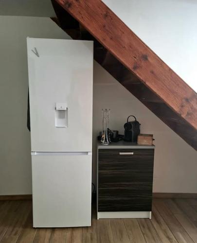 Cette chambre dispose d'un plafond en bois et d'un réfrigérateur blanc. dans l'établissement Maison au cœur du Revermont, à Ménétru-le-Vignoble
