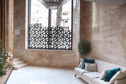 a living room with a white couch and a window at Hotel Constantine the Great in Belgrade