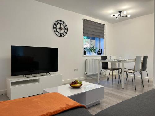 a living room with a television and a table with chairs at Modern 3 Bedroom House, Free Parking in Oxford in Oxford