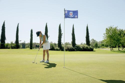 a woman is playing golf on a golf course at Hotel Giardino in Prato