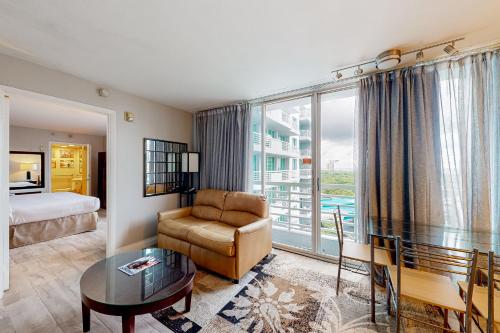 a hotel room with a bed and a couch and a table at Views of the City, 1002 in Fort Lauderdale