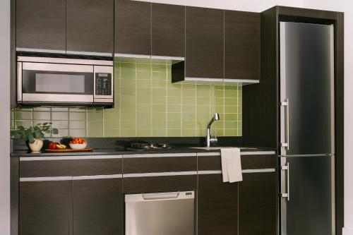 eine Küche mit braunen Schränken und einem Kühlschrank aus Edelstahl in der Unterkunft Sonder at One Platt in New York