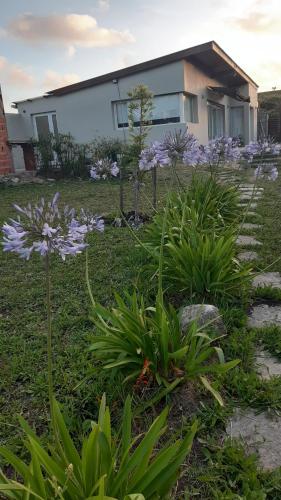 a garden with purple flowers in front of a house at Casa in Mar del Plata