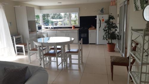 a kitchen with a table and chairs and a kitchen with a refrigerator at Casa in Mar del Plata