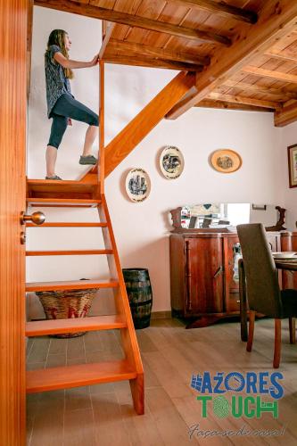 a woman is climbing a ladder in a room at Atlântida Dream T2 in Angra do Heroísmo