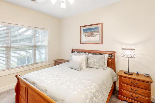 a bedroom with a bed and a lamp and a window at Gardens at Cypress Bay 103 in Little River