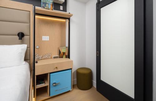 a bedroom with a bed with a blue drawer and a mirror at Little Charlie Hotel in New York