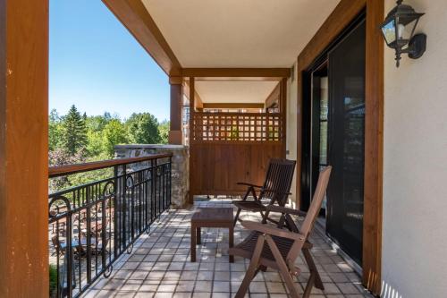 a screened porch with two chairs and a table at Hotel Quintessence in Mont-Tremblant