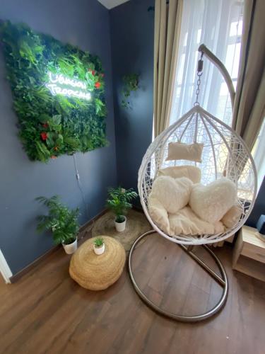 a swinging chair in a room with plants at Grand studio avec spa, cosy et rénové au cœur de Soissons in Soissons