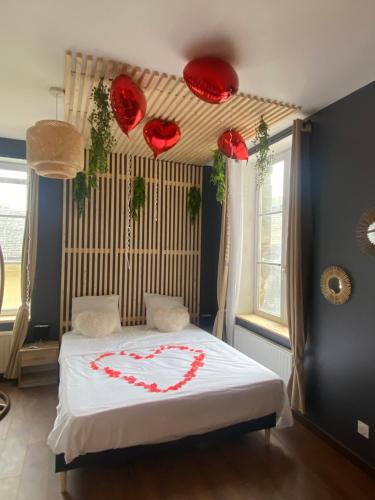 een slaapkamer met een bed met een hart erop bij Grand studio avec spa, cosy et rénové au cœur de Soissons in Soissons