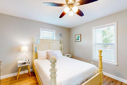 sypialnia z łóżkiem i wentylatorem sufitowym w obiekcie Out of the Blue w mieście Galveston