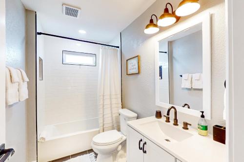biała łazienka z umywalką i toaletą w obiekcie Out of the Blue w mieście Galveston