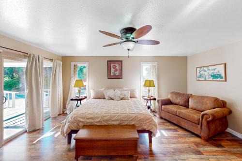 1 dormitorio con cama, sofá y ventilador de techo en Peppermint Falls Hideaway, en Jamestown