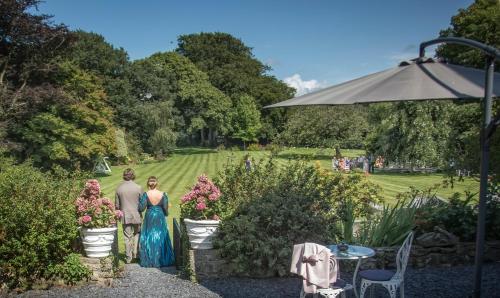 a man and a woman standing in a garden at Plas Dinas Country House in Caernarfon