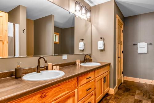 La salle de bains est pourvue de 2 lavabos et d'un grand miroir. dans l'établissement Anvil Lake Lodge, à Eagle River