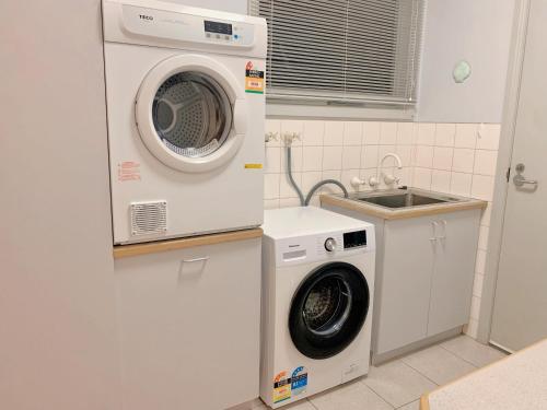 a washing machine and a sink in a kitchen at The peaceful retreat in Mulgrave