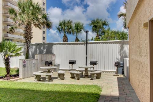 a patio with tables and chairs and palm trees at Navarre Towers 602 in Navarre