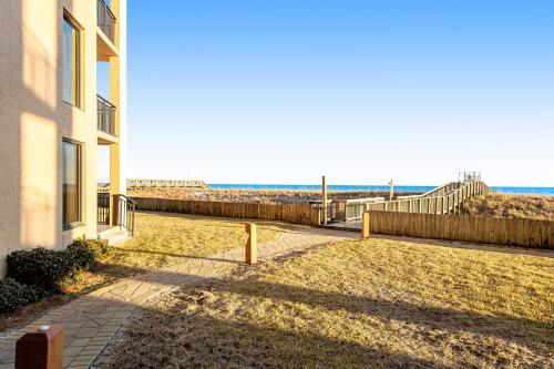 a building on the beach with the ocean in the background at Navarre Towers 602 in Navarre