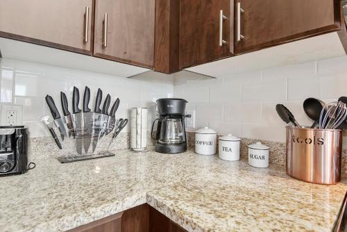 a kitchen counter with utensils and a coffee maker at Tampa Tropical-10 Min to Airport in Tampa