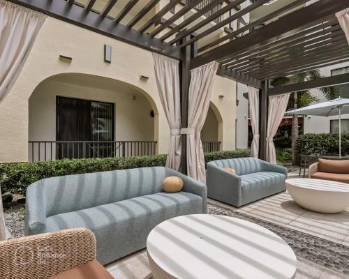 a patio with a couch and chairs and a table at Tampa Tropical-10 Min to Airport in Tampa