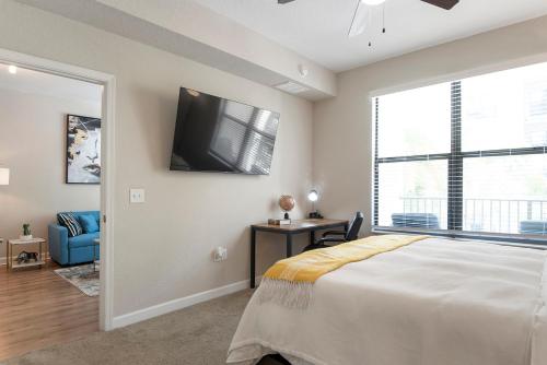 a bedroom with a large bed and a tv on the wall at Tampa Tropical-10 Min to Airport in Tampa