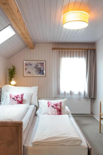 a bedroom with two beds and a window at la belle vue Boutique Hotel & Café in Spiez