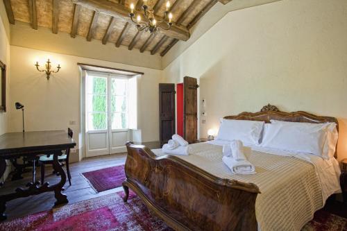 a bedroom with a large bed and a piano at Villa San Pietro in Cortona