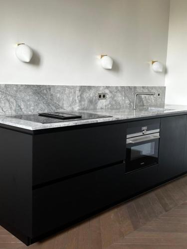 - une cuisine avec un comptoir noir et un évier dans l'établissement Luxury flat - Paris - Eiffel Tower - 2 rooms, à Paris
