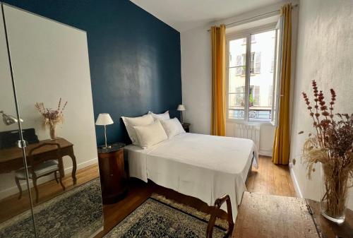 a bedroom with a bed and a table and a window at Maison de ville cosy Canal Saint Martin in Paris
