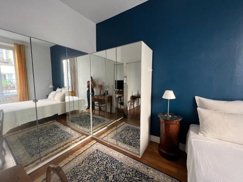 a bedroom with blue walls and a glass room at Maison de ville cosy Canal Saint Martin in Paris