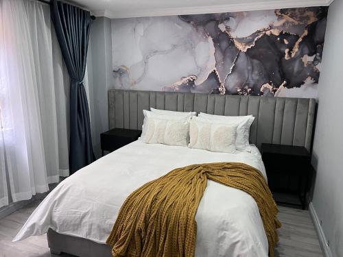 een slaapkamer met een bed met een deken erop bij 404 on 9 Palm Blvd in Durban