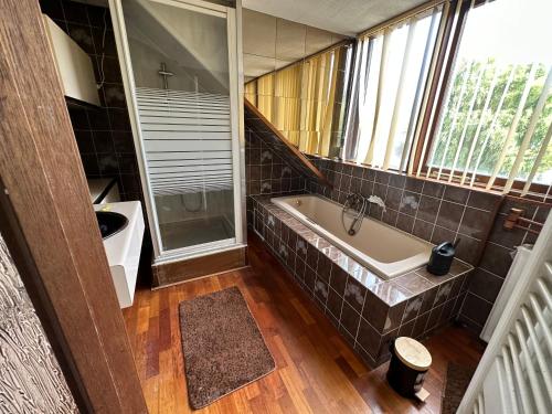 een badkamer met een bad, een wastafel en een raam bij Wow in Rotterdam