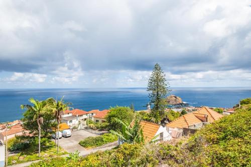 uitzicht op een stad met de oceaan op de achtergrond bij De Freitas Home in Porto Moniz