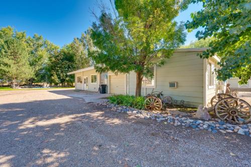 a house with a tree next to a building at Cozy Idaho Retreat with Grill and Fire Pit! in Caldwell