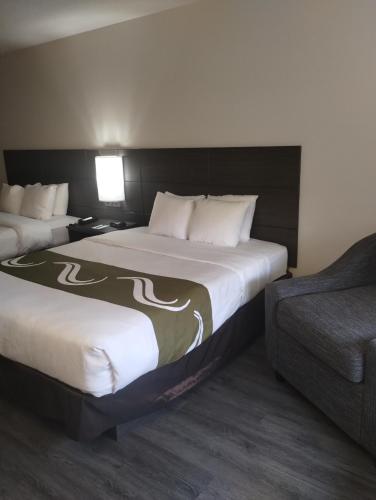 a hotel room with two beds and a couch at Quality Inn & Suites Wilsonville in Wilsonville
