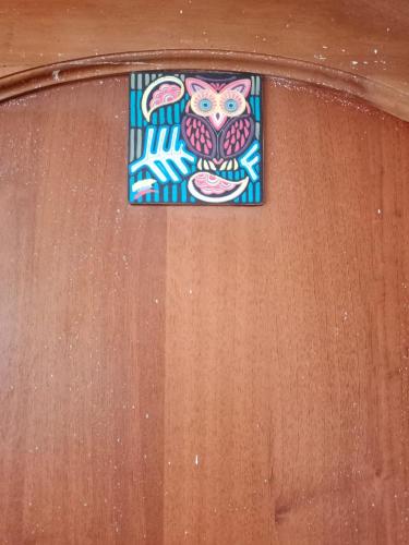 a stained glass window of an owl on a wooden wall at Casa Rural Zaba Lago de Tota in Aquitania