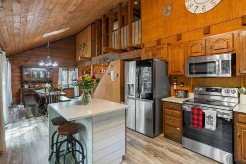 a kitchen with wooden cabinets and a counter with flowers on it at Rustic Luxury in the Pocono Mountains - Stag Lodge in Pocono Lake