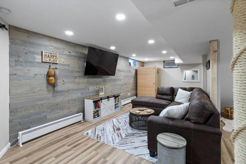 a living room with a leather couch and a fireplace at Rustic Luxury in the Pocono Mountains - Stag Lodge in Pocono Lake