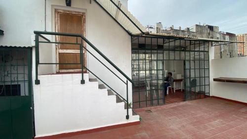 a person sitting at a table in a building with a staircase at Casa en el Encantador San Telmo - 8 habitaciones in Buenos Aires