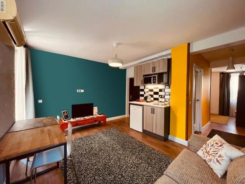 a living room with a blue and yellow wall at Cabbana Hotel Lara in Antalya