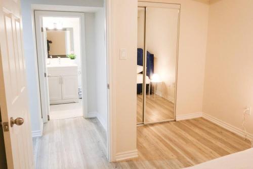 a hallway with a mirror and a bathroom at Garden Ave Suite 3 Mins to Hwy 403 in Brantford