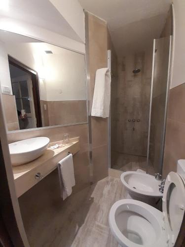 a bathroom with a toilet and a sink at Hotel Las Cascadas in La Cumbrecita