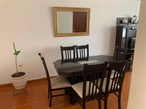 een eettafel met stoelen en een spiegel bij Casa por tecsup in Paucarpata