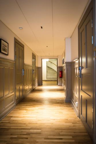 an empty hallway with doors and wooden floors at Continental Apartment Hotel Sundsvall in Sundsvall