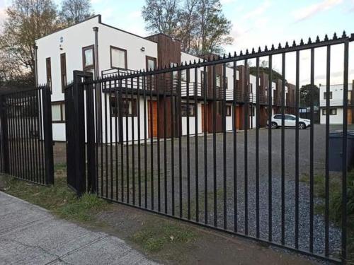 a black wrought iron fence in front of a house at Cabañas L Calafquen in Licán Ray