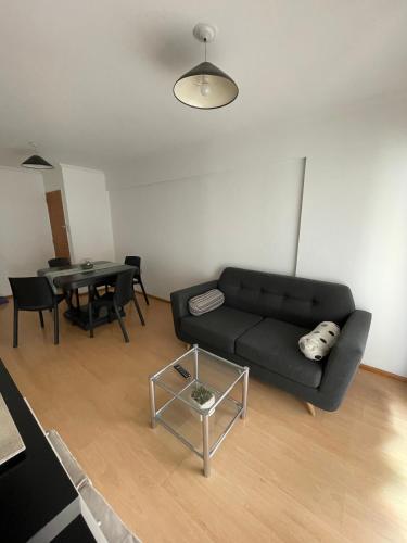 sala de estar con sofá negro y mesa en DEPARTAMENTO EN EL CORAZÓN DE NUEVA CÓRDOBA en Córdoba
