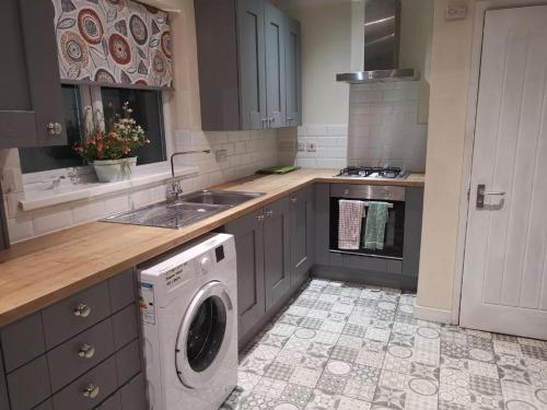a kitchen with a washing machine in the middle at Room Wollanton Park Beeston near East Midlands Conference Centre train station tram stop in Nottingham