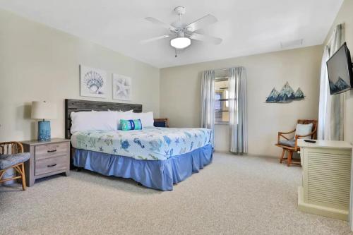 1 dormitorio con 1 cama y ventilador de techo en Tropical Pelican Beach Home en Clearwater Beach