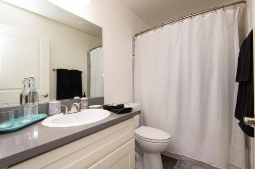 a white bathroom with a sink and a toilet at Prime Location 1-Bedroom with Pool in Los Angeles